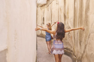 Women travelling in beautiful Italy relaxing summer vacation exploring coastal Amalfi walking stairs sightseeing Gopro